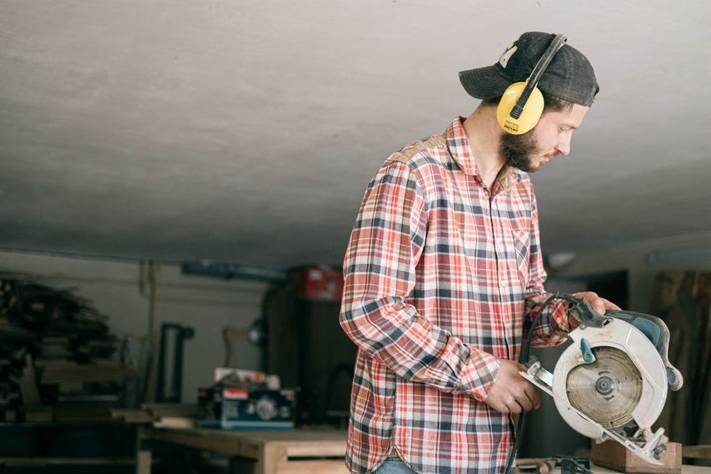 bricoleur portant un casque anti-bruit avec une scie circulaire